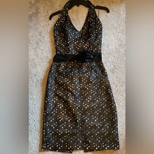 Black halter style party dress with design and silt in the back. Flower on belt.
